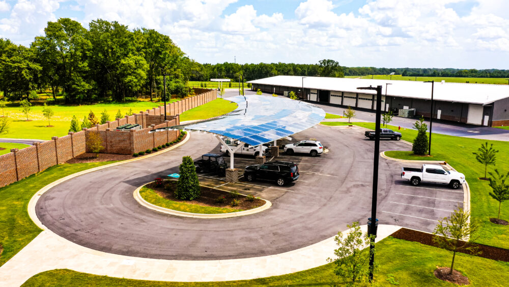 Aerial view of curved, weatherproof solar carport in parking lot of Marlboro Electric Coop