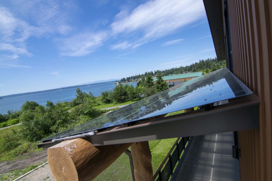 Solar Panels cover walkway with view of trees and lake in background.