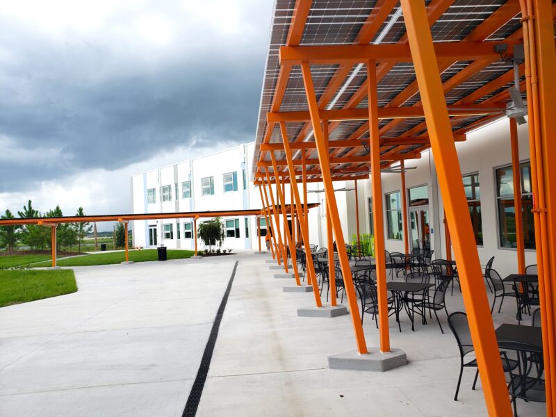 Custom LSX Solar Canopies providing shaded seating area and walkway at K-12 school with solar energy for outside eating and recreating.