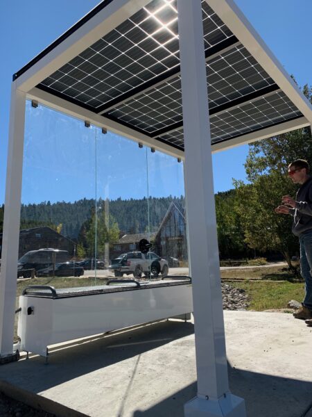 GSX Bifacial translucent solar panels on this solar bus stop shelter provides protection, shade, wireless charging, wifi and lighting while letting the natural light shine through.